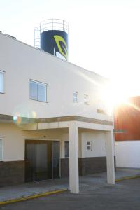 een wit gebouw met een watertoren erop bij Hotel Pro Tork Confort in Santo Antônio da Platina