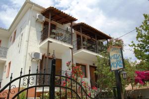 a white house with balconies and a sign in front of it at Hotel Villa Marie in Syvota