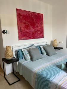 a bedroom with two beds and a painting on the wall at Beach Apartment Montemar No.1 - perfect ocean view in Sóller