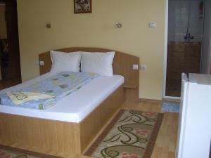 a bedroom with a bed with white sheets and a window at Villa Shipkovo in Shipkovo
