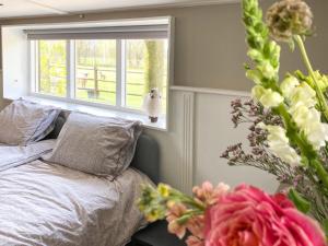 a bedroom with a bed and a window and flowers at 4seasonshouse in Losser