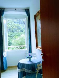 Cette chambre comprend une table et une fenêtre. dans l'établissement VILLA MONICA Diano San Pietro (IM) Italy, à Diano San Pietro