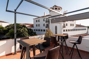 a patio with tables and chairs on a balcony at Templo Boutique Hotel in Évora