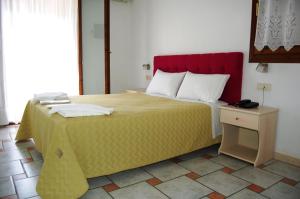 a bedroom with a large bed with a red headboard at Hotel Villa Marie in Syvota