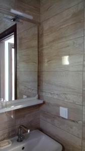 een badkamer met een wastafel en een spiegel bij Kandis Place in Metamorfosi