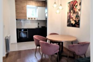 a kitchen with a wooden table and purple chairs at SNP city center lux in Novi Sad