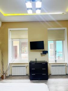 un soggiorno con 2 finestre e una TV a schermo piatto di Your apartment City Center Lviv a Lviv