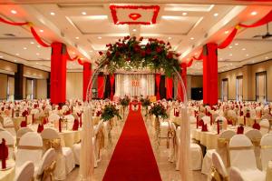 a banquet hall with white tables and chairs and a red carpet at StarCity Hotel in Alor Setar