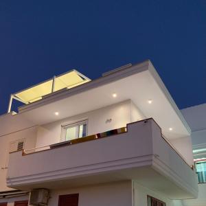 una casa bianca con un balcone sopra di Virgilio hosting Casa Nuovissima Vista Mare a Torre Pali