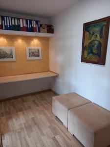 een kamer met een bank en een plank met boeken bij Apartament Promenada in Częstochowa