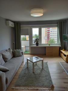 een woonkamer met een bank en een salontafel bij Apartament Promenada in Częstochowa