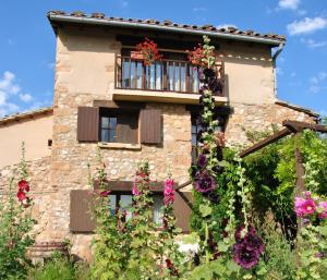 a building with a balcony with flowers on it at B&B Casa Rural Mas de las Tapias in Valderrobres
