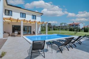 um pátio com piscina e cadeiras e uma casa em Villa Lemoar Pula em Pula