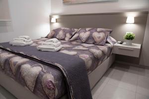 1 dormitorio con 1 cama con toallas en Virgilio hosting Casa Nuovissima Vista Mare, en Torre Pali