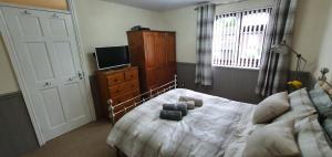 a bedroom with a bed and a dresser and a tv at Double room near Telford Town centre in Telford