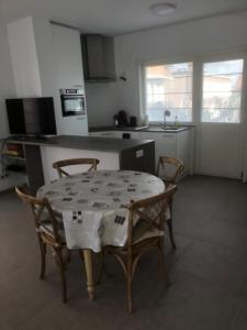 eine Küche mit einem Tisch, 2 Stühlen, einem Tisch und einer Küche in der Unterkunft Appartement - Vakantiehuis Manou in De Panne