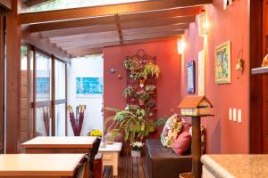 sala de estar con paredes de color naranja y mesa en Pousada Casario en Paraty