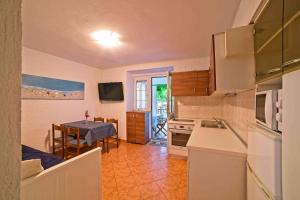 a kitchen and dining room with a table and a kitchen and a room at Beach Villa Ema with Heated Pool in Rab