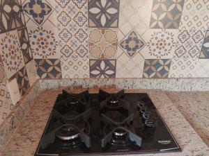 a stove top in a kitchen with tiles at Chalé caminho das cachoeiras in São Thomé das Letras