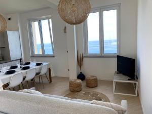 チェルヴォにあるIncanto sul mare con enorme terrazza e piscinaの白いソファとテーブルのあるリビングルーム