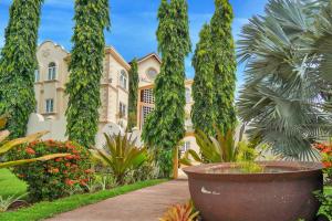 a building with trees in front of a garden at Mandela Court Suites Grenada in Lance aux Épines