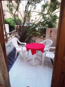 a table with a red seat on a patio at شاليه بقرية أندلسيه بمطروح يرى البحر in Marsa Matruh