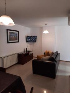 sala de estar con sofá y TV en Apartamento 2 Dormitorios - Córdoba - Norten en Córdoba