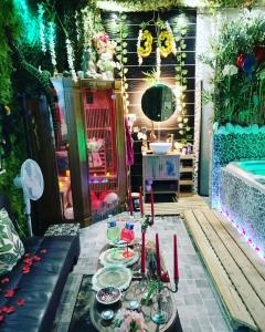 patio con tavolo, piatti e candele rosse di Jungle Vibes - Jacuzzi - Sauna a Yerres