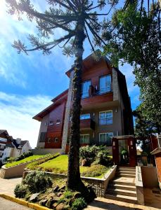 a building with a tree in front of it at Loft Gramado in Gramado