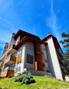 a building on a hill with a blue sky at Loft Gramado in Gramado