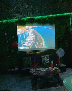 um palco com um ecrã com uma praia em Jungle Vibes - Jacuzzi - Sauna em Yerres