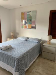 a bedroom with a blue and white bed and a painting at Casa Praia do Forte - Piscinas naturais in Farol +20 photos