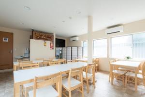 Hotel Sunmarine في Tarui: غرفة طعام مع طاولات وكراسي ونوافذ