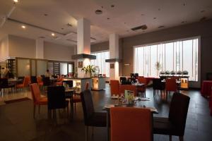 uma sala de jantar com mesas, cadeiras e janelas em StarCity Hotel em Alor Setar