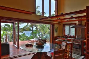a kitchen with a table and a view of the ocean at Kaireva Beach House in Rarotonga