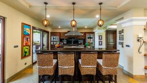 a kitchen with a large island with bar chairs at Stunning beachfront Flamingo mansion with incomparable ocean setting in Playa Flamingo