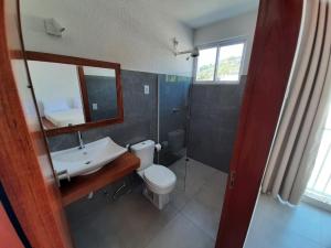un bagno con un water, un lavandino e uno specchio di Pipa Bavaria Boutique a Pipa Altre 19 foto