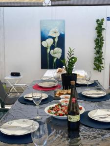 een tafel met borden en een fles wijn bij Kerart Lima in Armação de Pêra