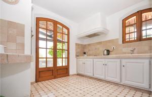 une cuisine avec des armoires blanches et une porte en bois dans l'établissement Amazing Home In St Cézaire Sur Siagne, à Saint-Cézaire-sur-Siagne