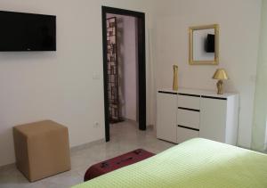 a bedroom with a bed and a dresser and a television at Camere Amarzè Plus in Portopalo