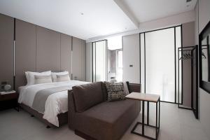 um quarto com uma cama grande e um sofá em Manho Hotel em Taichung