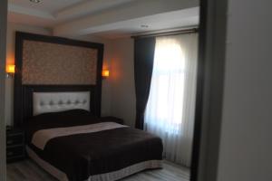 A bed or beds in a room at Oz Cavusoglu Hotel