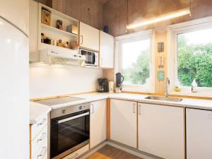 a kitchen with white cabinets and a sink and a window at Four-Bedroom Holiday home in Gilleleje 1 in Gilleleje