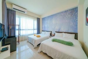 une chambre d'hôtel avec deux lits et une grande fenêtre dans l'établissement Jenny Inn, à Wujie