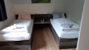 two beds in a room with a table and a bed at Ferienwohnung UP Willingen-Schwalefeld in Willingen