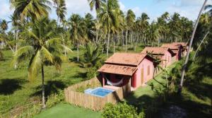 an aerial view of a resort with palm trees at Chalés Solar do Patacho in Pôrto de Pedras