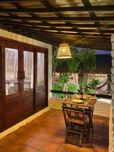 un patio con mesa, sillas y una lámpara de araña en Recanto de Ibiza, en Pipa