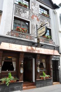 un edificio con una señal delante de él en Hotel Gasthof Schuster und Gästehaus en Rüdesheim am Rhein