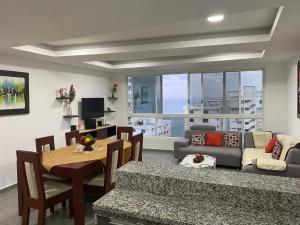 sala de estar con sofá y comedor en KattyApartament1102, en Salinas