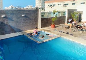 a group of children playing in a swimming pool at KattyApartament1102 in Salinas